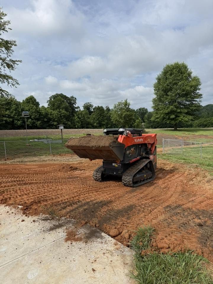 Hauling dirt across an open lot with a track loader.